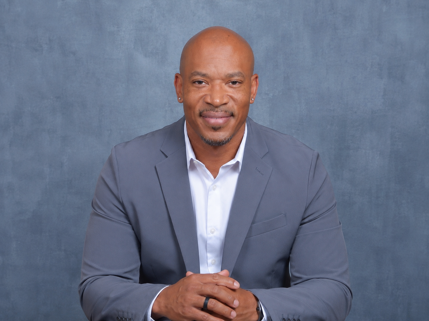 Lamar Jackson, Co-Founder and Co-Chair of Legacy Raising Foundation, wearing a gray suit